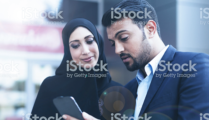 https www.istockphoto.com gb photo modern arab husband showing his wife an online message on his smart phone gm693801250 128177499